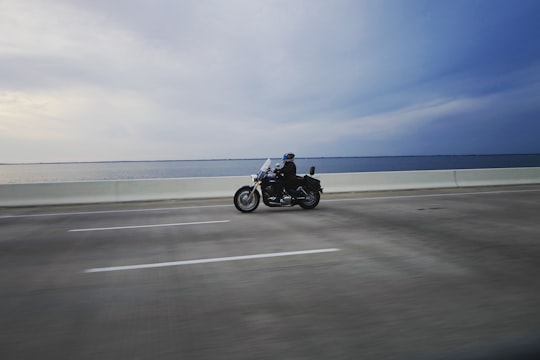 person riding touring motorcycle on gray concrete road in Howard Frankland Bridge United States