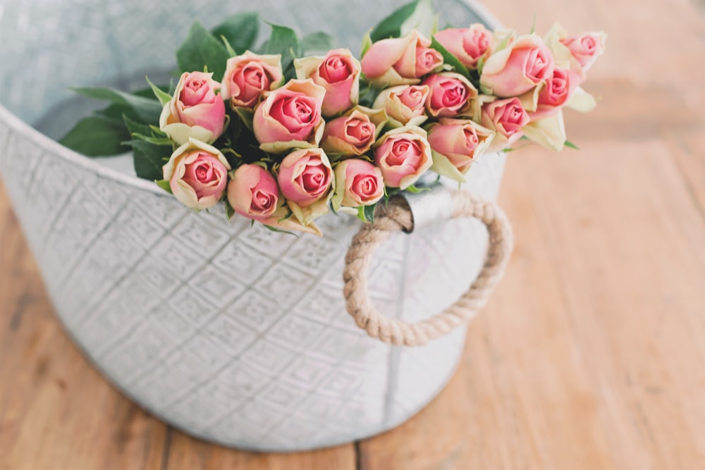 Flachfokusfotografie von Strauß rosa Blume im weißen Eimer