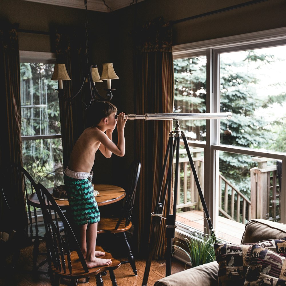 boy looking through telescope