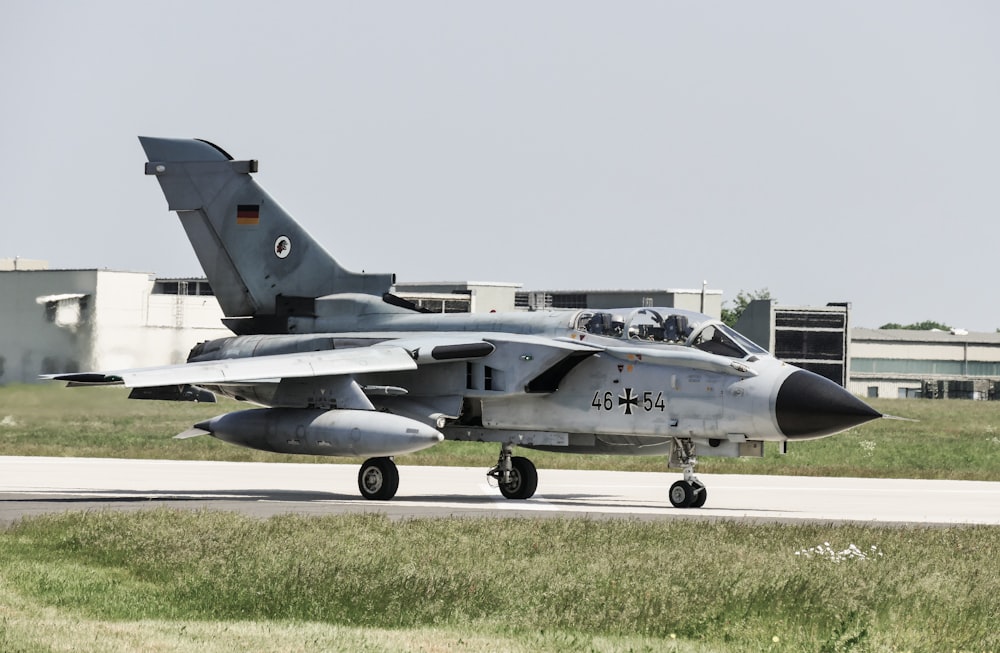 gray fighter jet on gray concrete ground during daytime