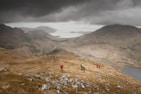 A group of friends wearing different styles of TrailDry jackets on a rugged mountain path.
