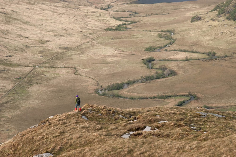 person standing on brown hill