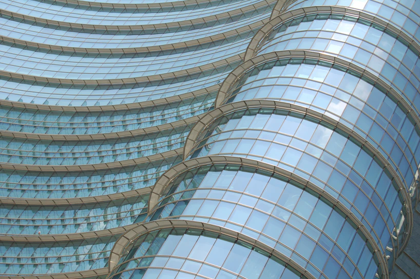 A modern architectural project showcasing a sleek glass facade reflecting the sky.