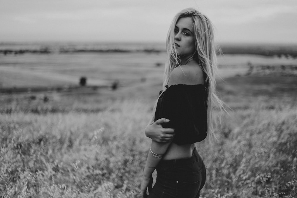 woman in black off-shoulder crop-top standing on grass field