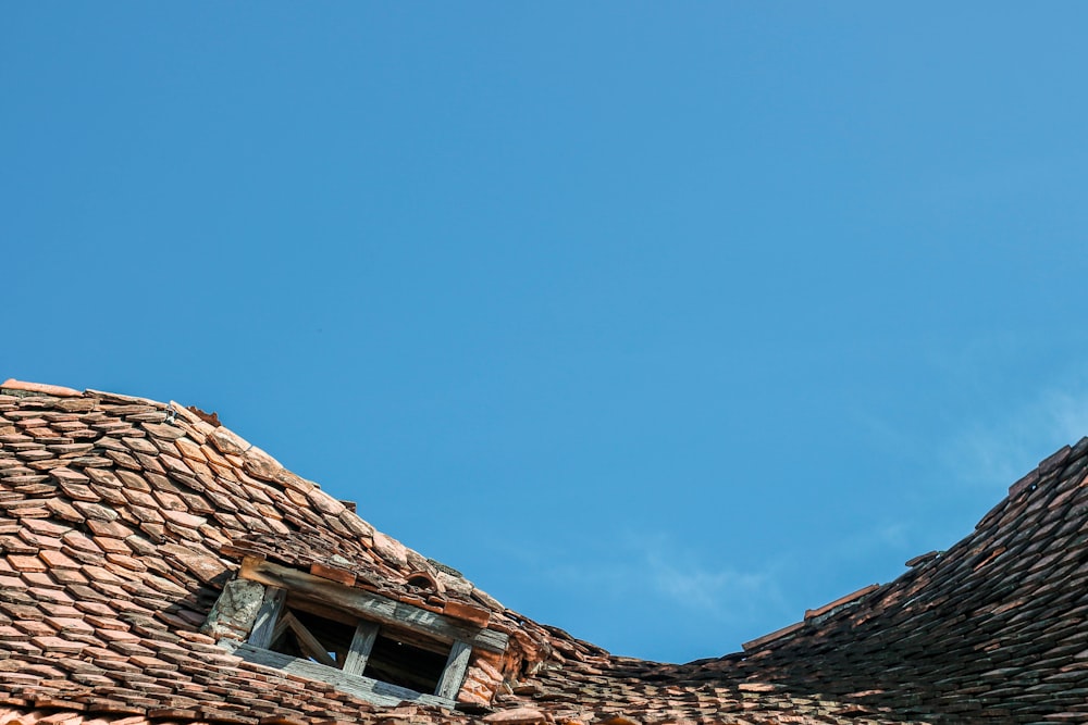 Toit en brique marron sous ciel bleu pendant la journée