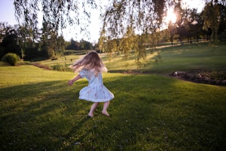 girl dancing on green grass field