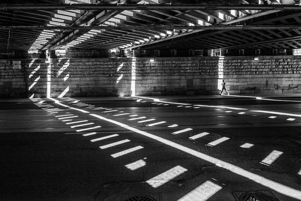 grayscale photography of man walking on road