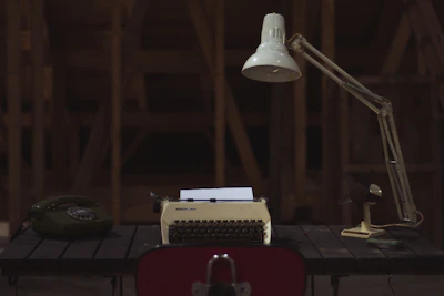 A vintage facsimile machine resting on a wooden desk bathed in warm light.
