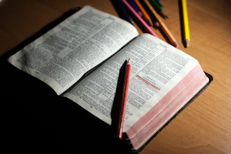Colorful illustrated Bible storybook open on a wooden table with crayons and children's hands nearby