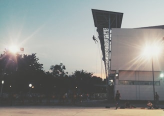 Worker rappelling down a tall structure during a maintenance operation.
