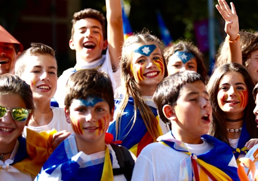 A group of kids gathered around a tropical-themed face painting station with smiles all around.