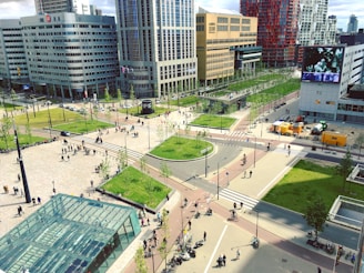 An urban landscape featuring a busy intersection surrounded by modern high-rise buildings and a public square. There is a large glass structure in the foreground, numerous pedestrians walking, and some cyclists on the pathways. Green spaces with neatly arranged trees add a touch of nature to the cityscape.