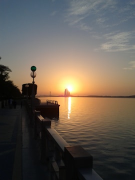 A sweeping drone shot of Liverpool's waterfront at sunset, with golden light reflecting on the water.