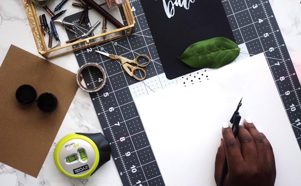 Math tools and utensils, a green leaf, piece of paper and other items.