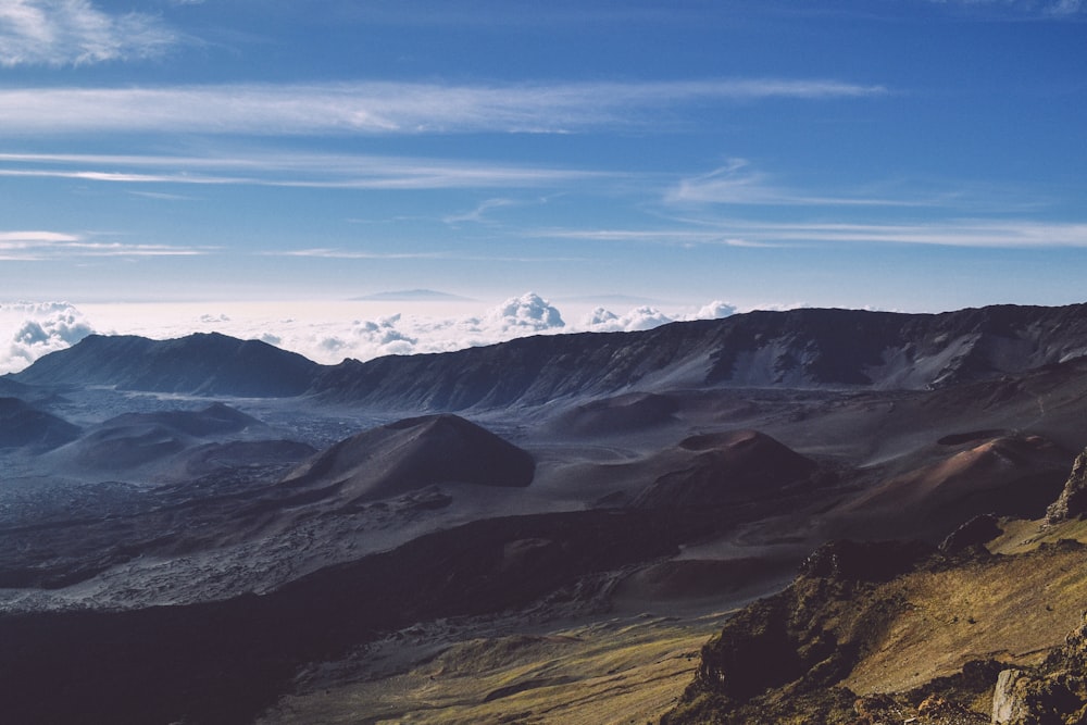 montagna marrone sotto il cielo nuvoloso bianco