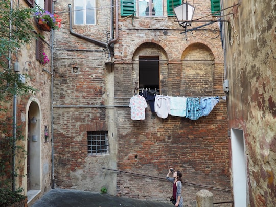 woman taking photo of apartment-type house in Province of Siena Italy