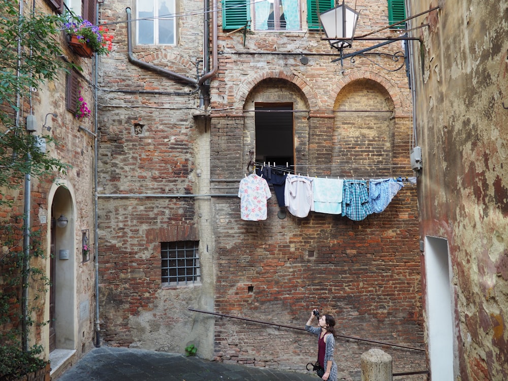 femme prenant une photo d’une maison de type appartement