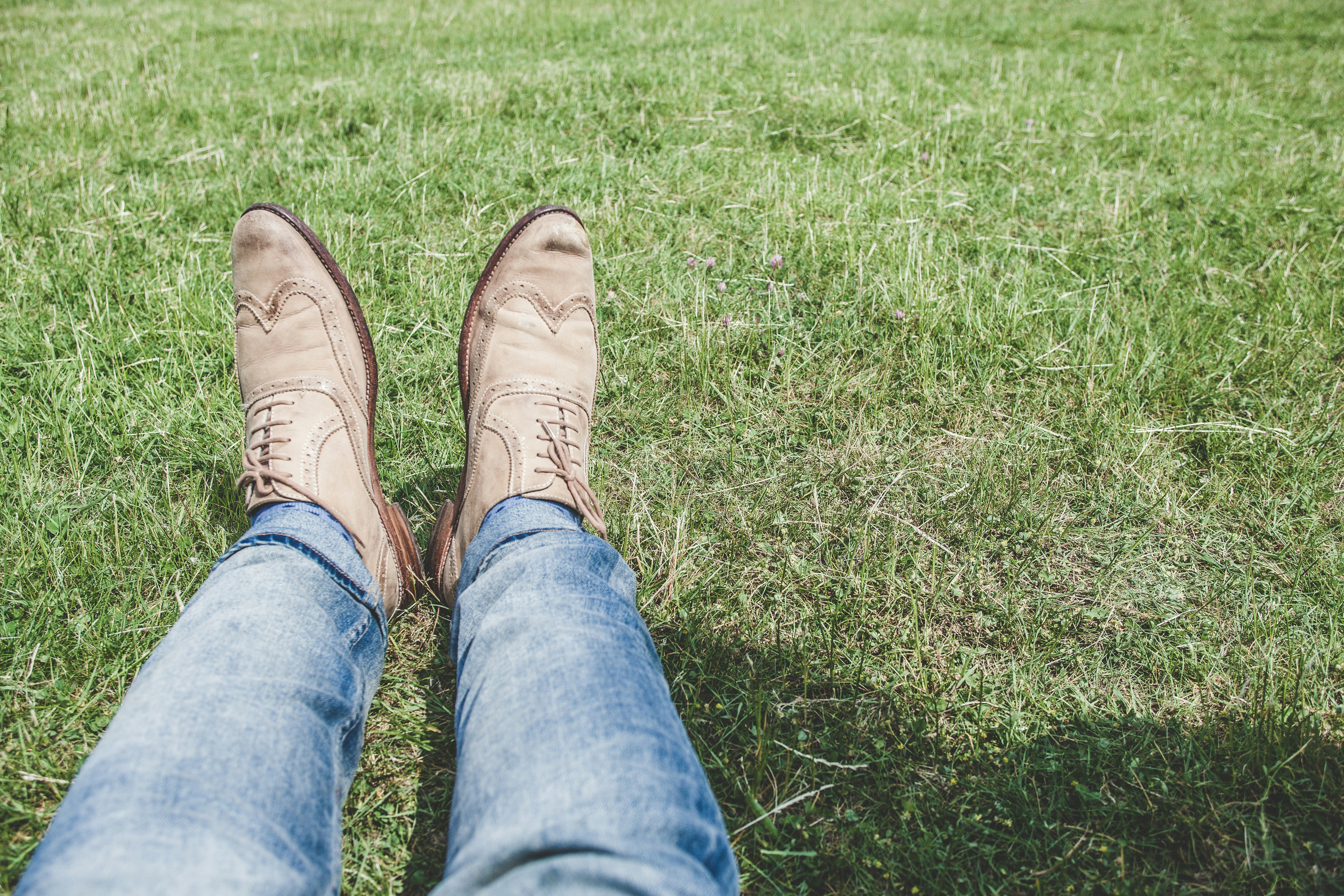 person wearing blue jeans and pair of white shoes boot teams background