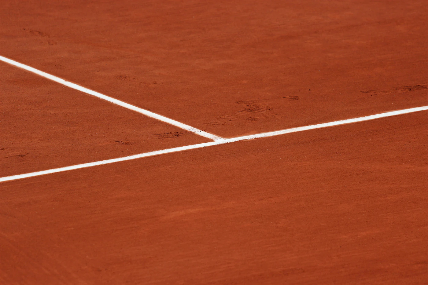 Red clay tennis court with white lines at Roland Garros in Paris