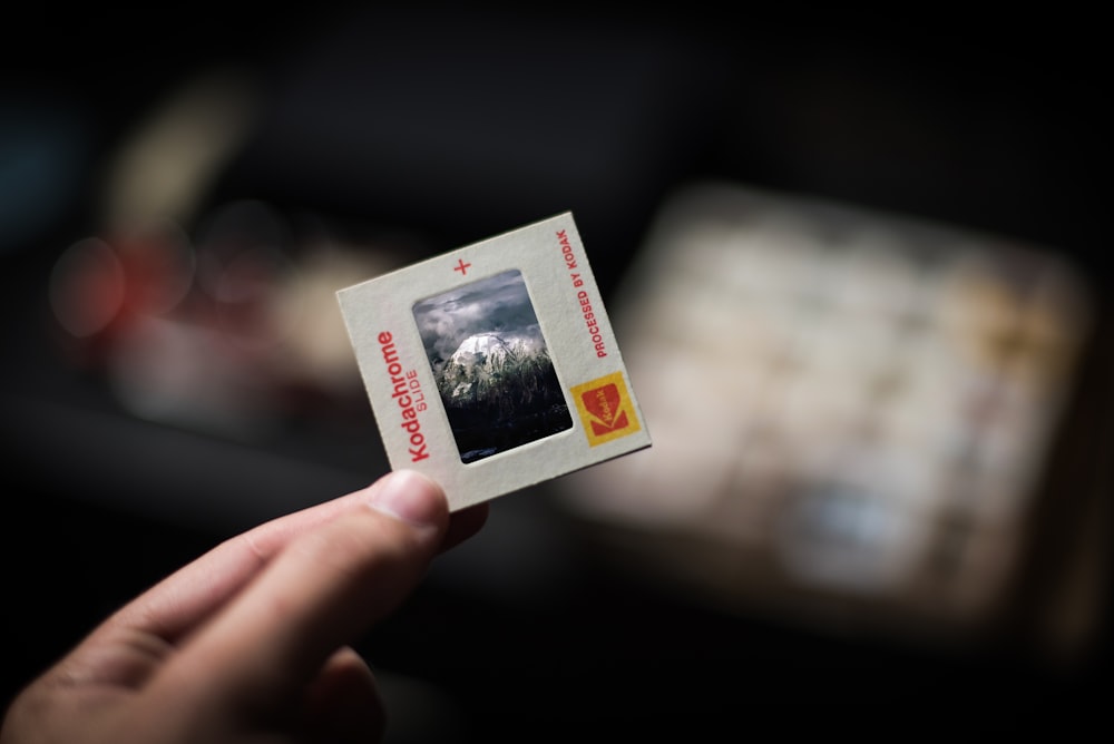 person holding white Kodachrome box