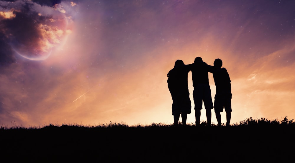 a group of people standing on top of a grass covered field