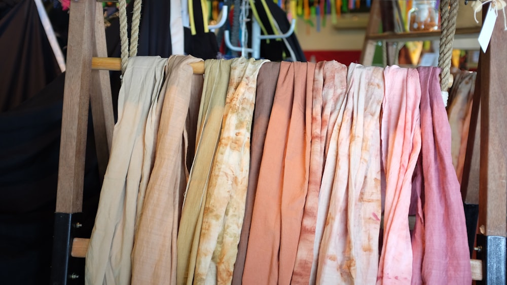 assorted scarves on brown wooden rack