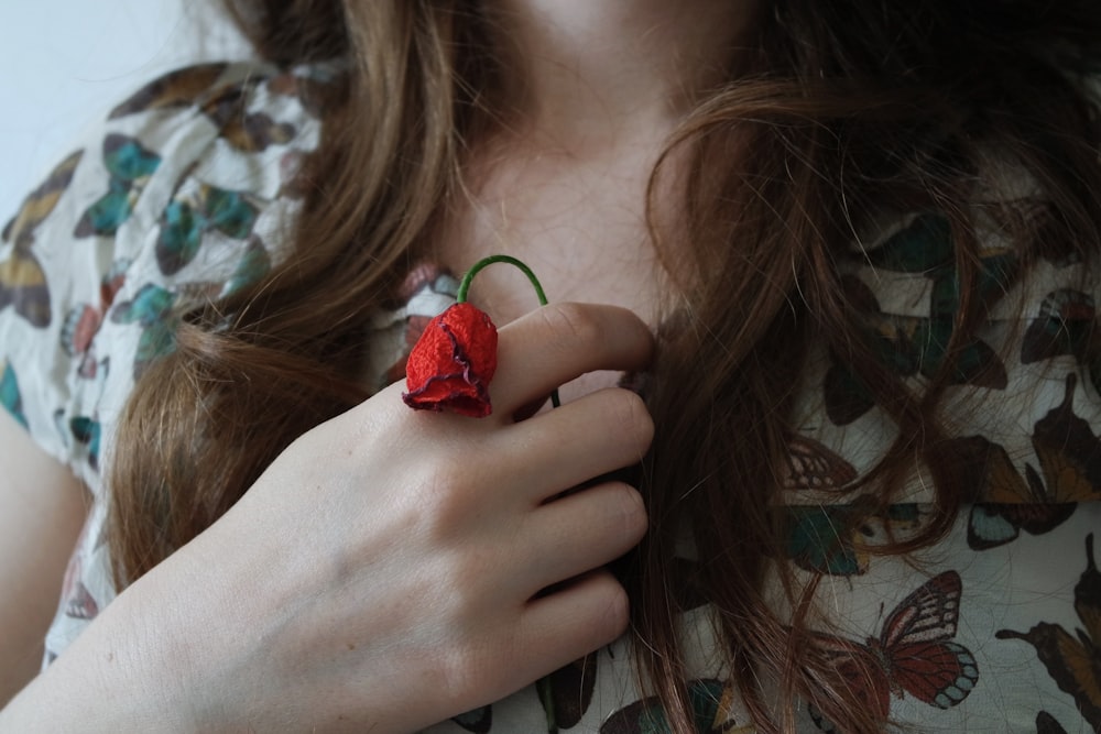 femme tenant une rose rouge