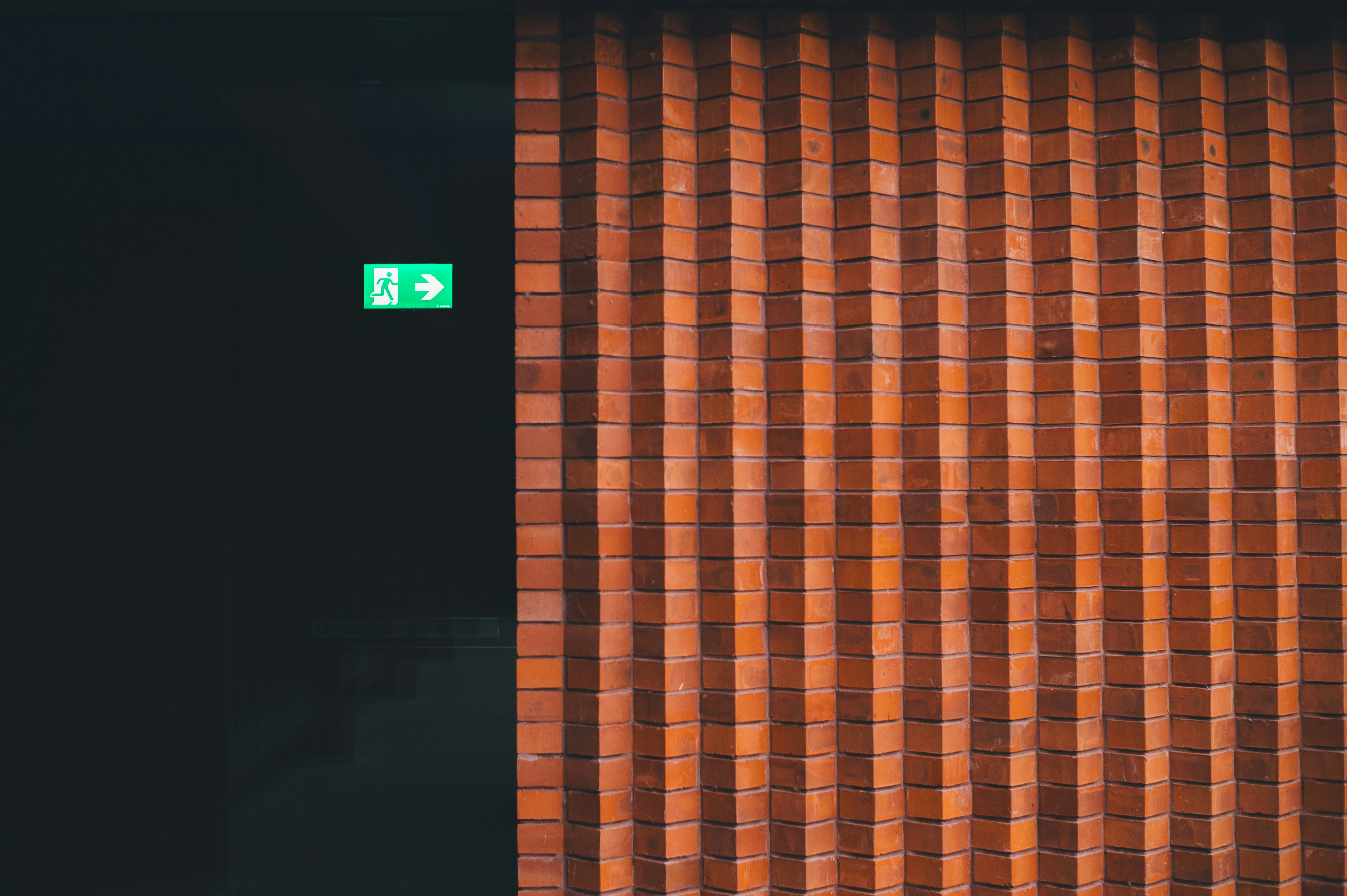 Exit sign next to brick wall