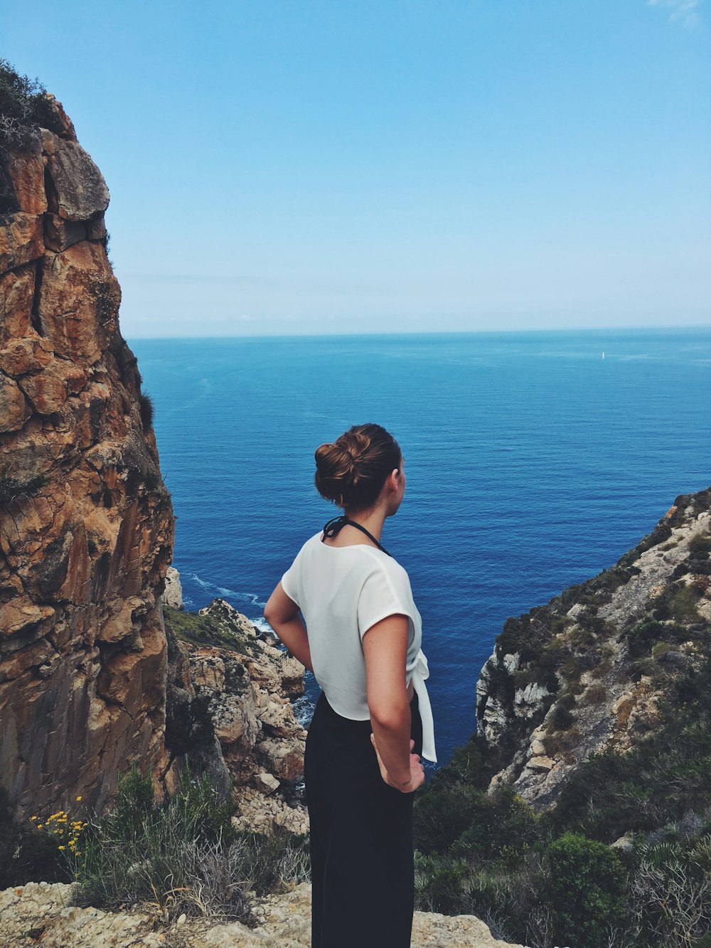 woman standing near mountain cliff