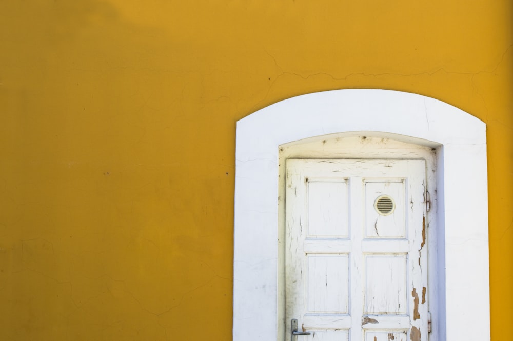 parede amarela com porta de madeira branca