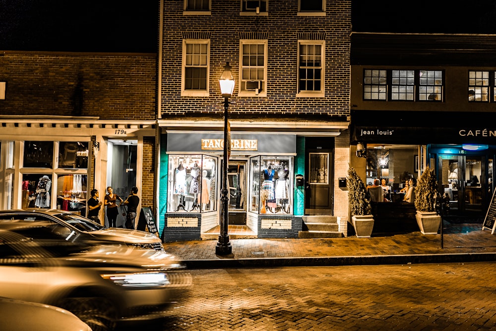 Young people talking near storefronts in Annapolis at night