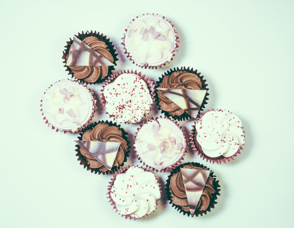 Lot de cupcakes assortis sur surface blanche