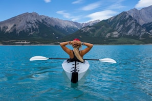 woman relaxing on a kayak in the middle of a lake