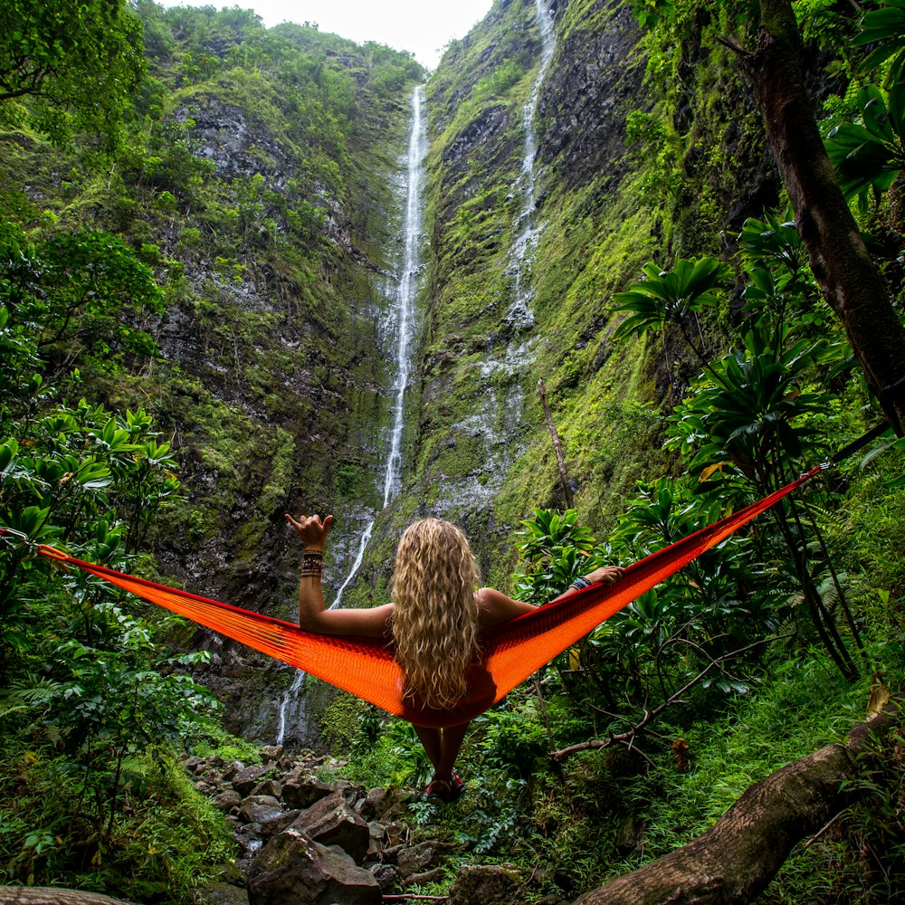 woman on hammock facing waterfalls