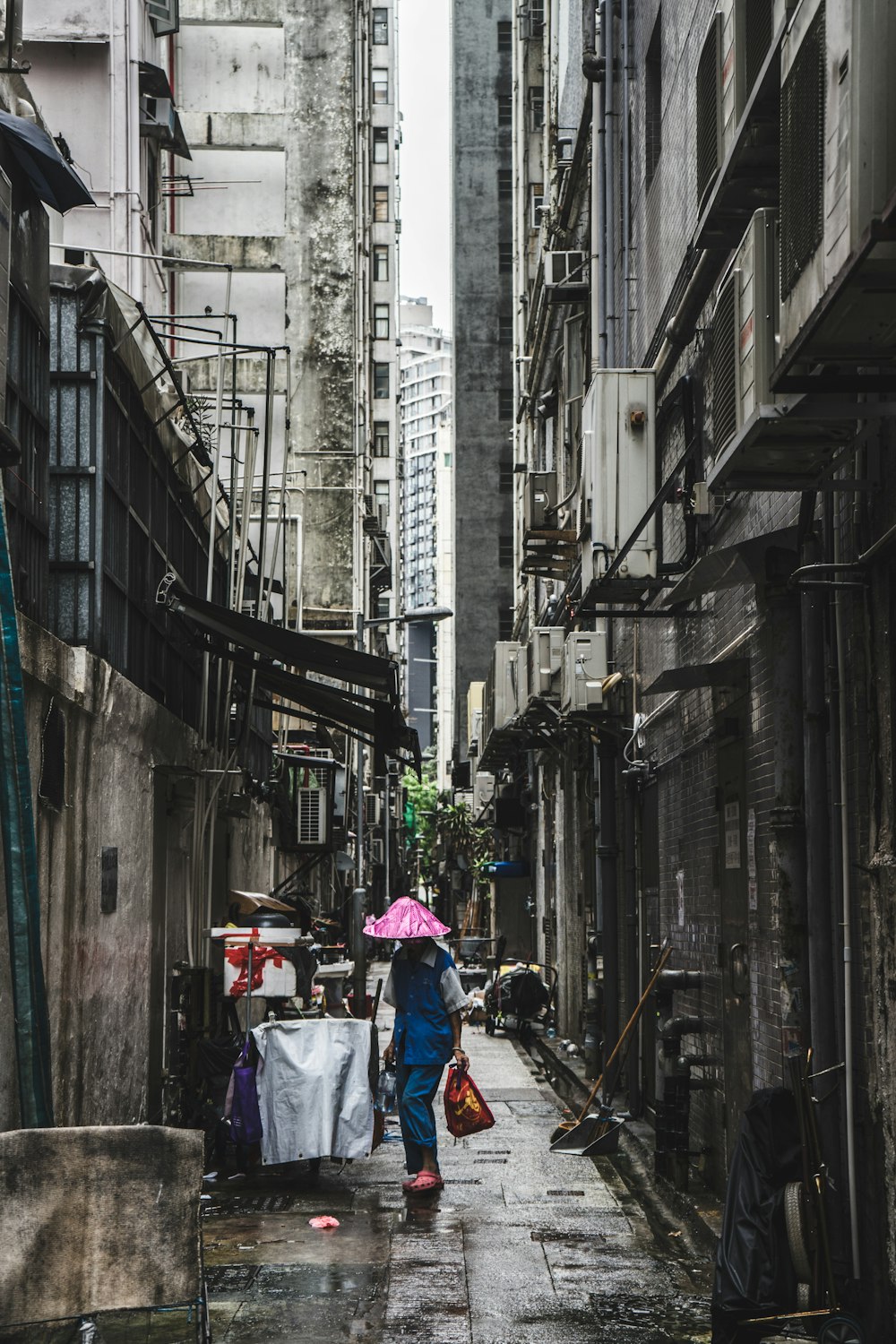 person carrying red bag in alley