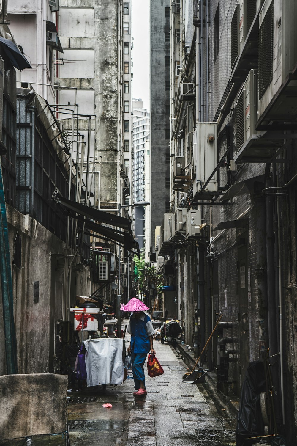 Persona que lleva una bolsa roja en un callejón
