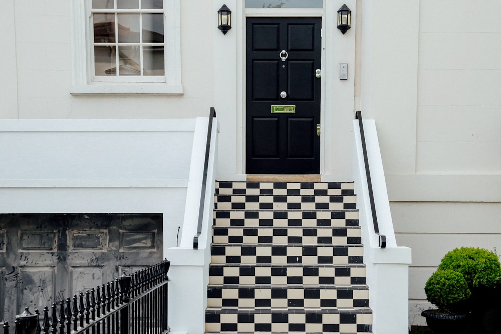 closed white and black house with checked staircase
