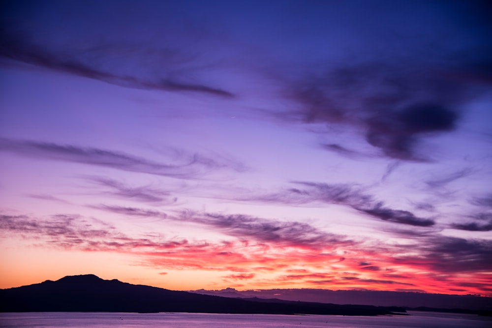 Blick aus einem niedrigen Winkel auf violette und orangefarbene Wolken während des Sonnenuntergangs