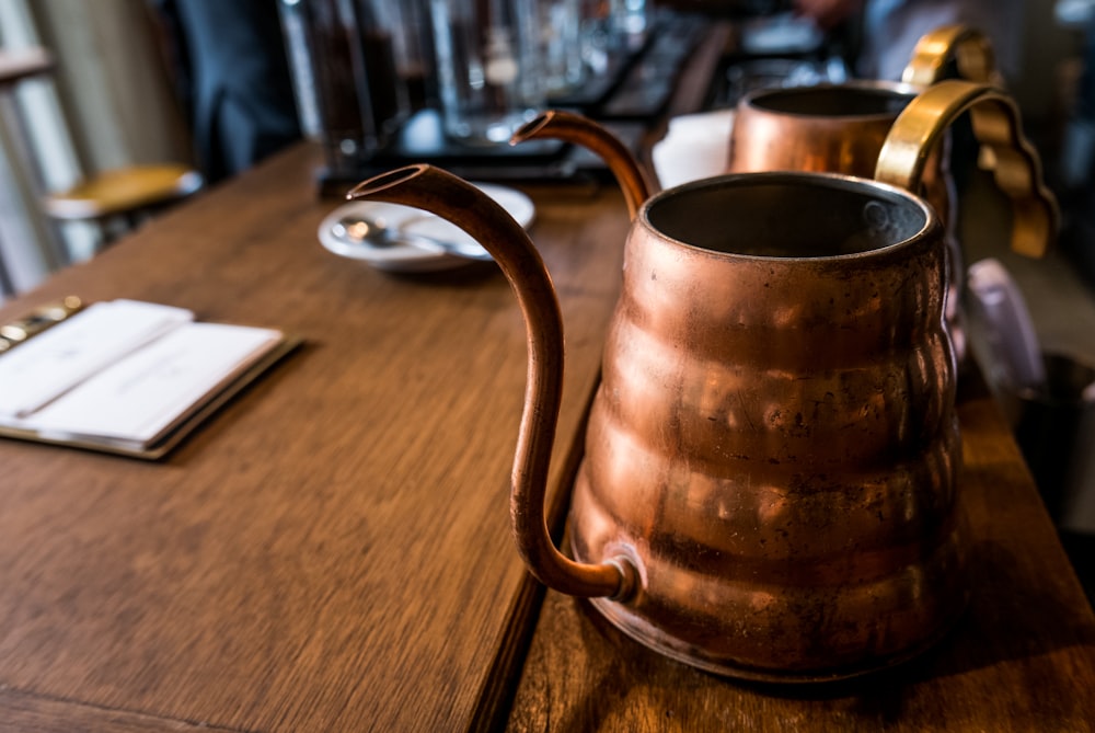 tilt shift photography of vintage brass teapot