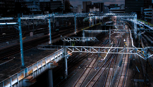 An aerial view of a sprawling, complex metro network under construction at dusk.
