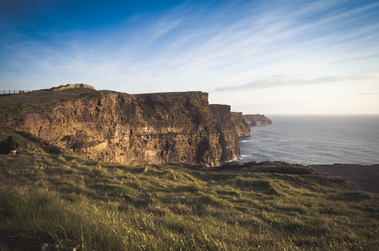 landscape photography of rock formation with body of water in Cliffs of Moher Ireland