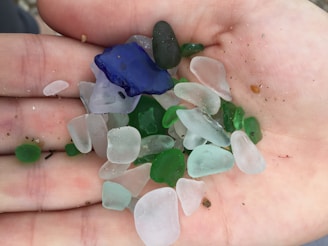 An artistic display of various sea glass shapes and colors in natural light.