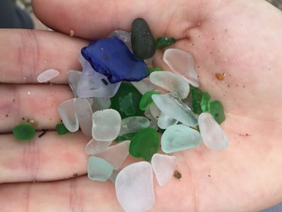 An artistic display of various sea glass shapes and colors in natural light.