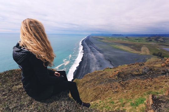 woman looking at seashore in Dyrhólaey Iceland