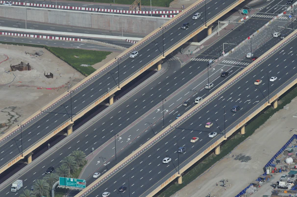 A wide shot of a busy highway tollroad construction site with heavy machinery and workers coordinating.