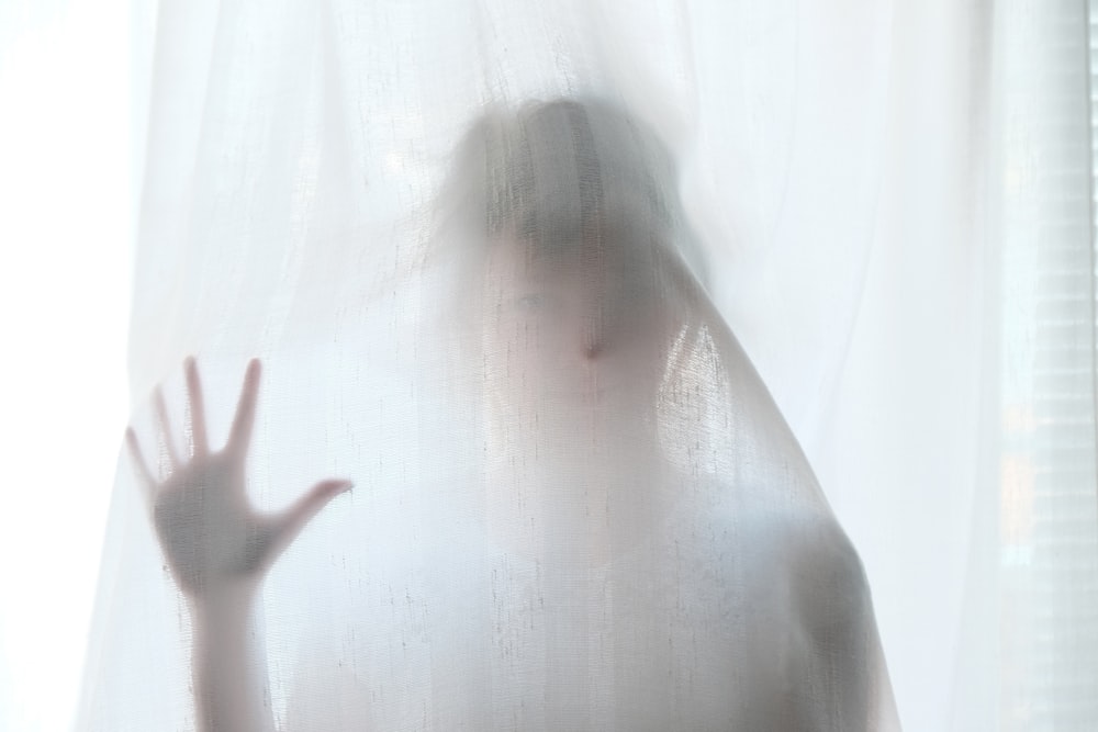 woman holding behind curtain