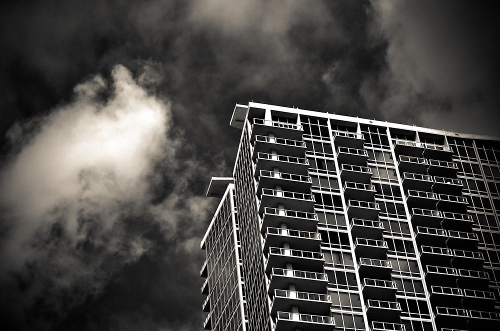 grayscale photography of building under cloudy sky