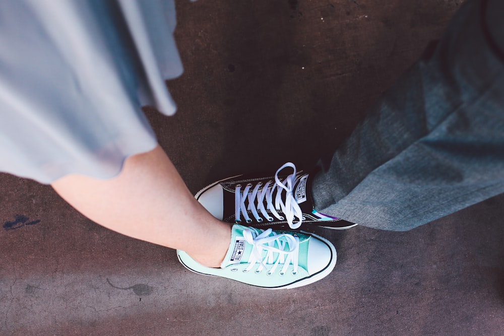 persona vestida de azul azulado y blanco Converse All-Star de caña baja