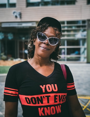 selective focus photography of woman wearing black V-neck shirt near building at daytime