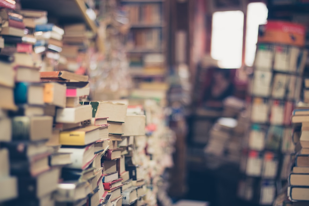 A bookshop with stacks and stacks of old books on the perimeter of the walls